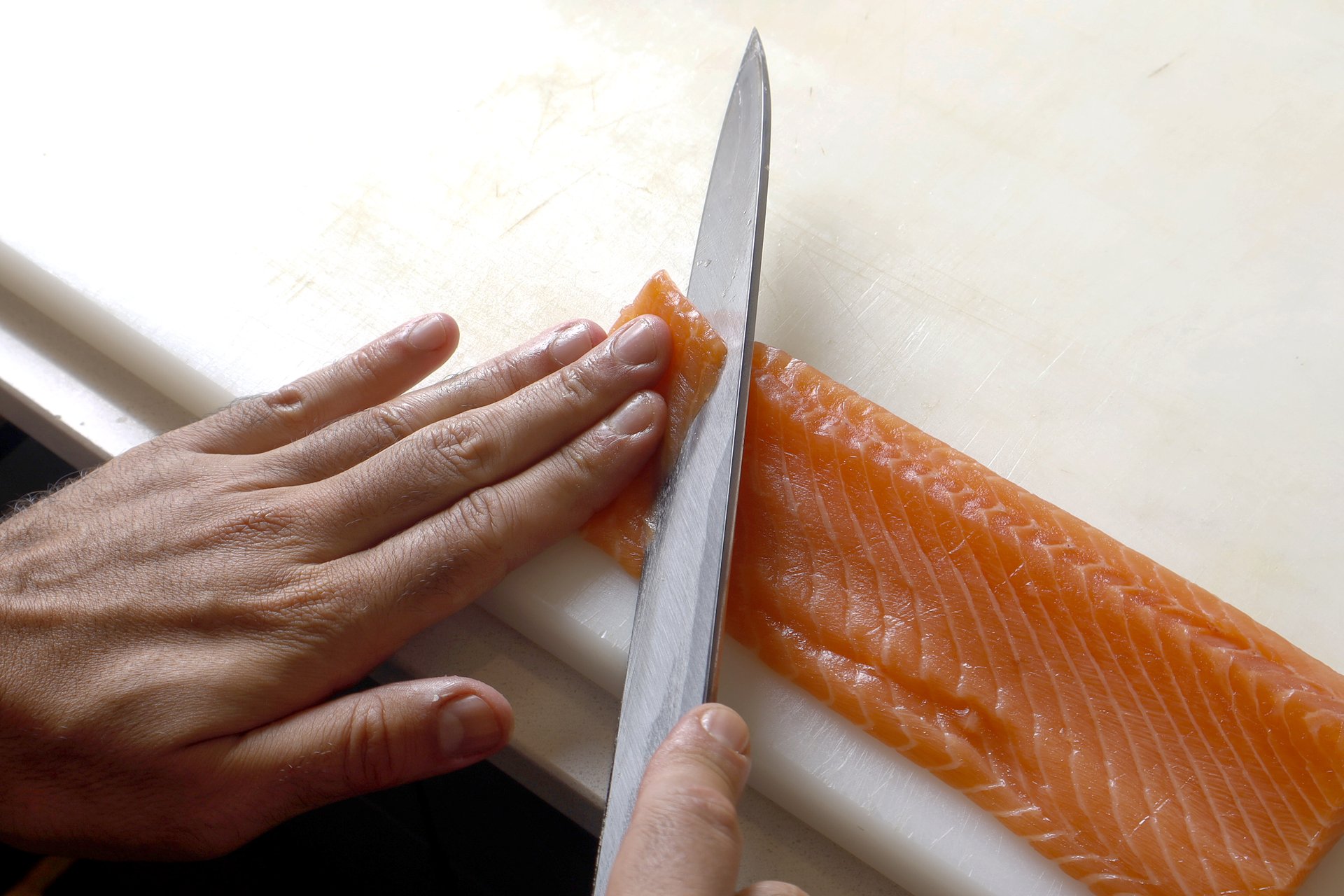Corte preciso do salmão pelo chef com faca tradicional