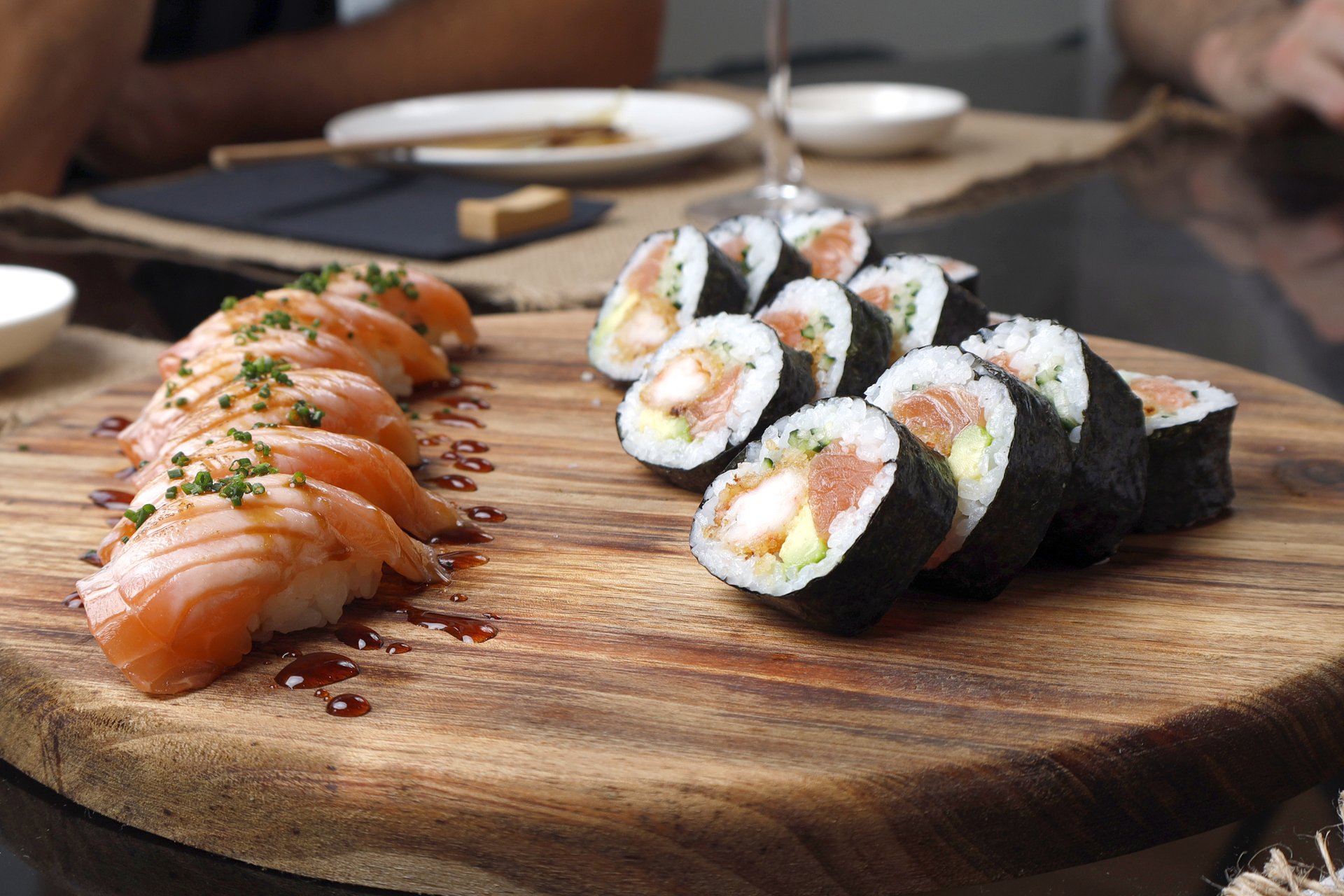 Tábua redonda de sushi com nigiris e rolls frescos